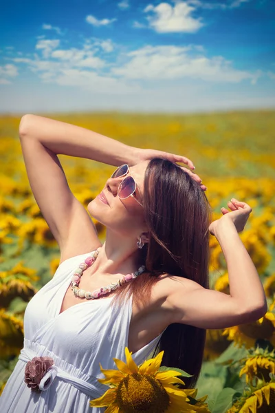 Mujer joven en el campo de belleza con girasoles —  Fotos de Stock