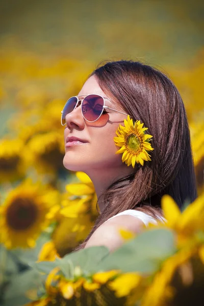 Jonge vrouw met zonnebloemen terzake schoonheid — Stockfoto