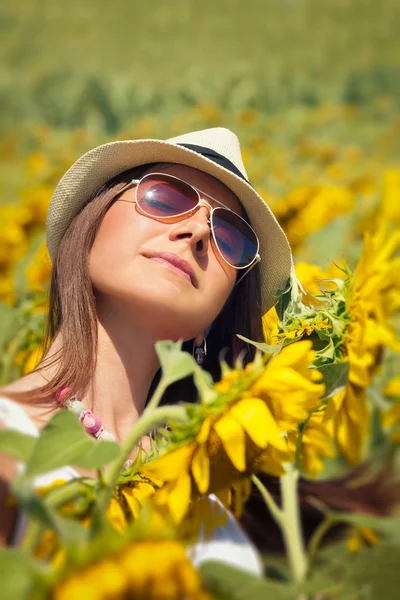 Junge Frau im Schönheitsfeld mit Sonnenblumen — Stockfoto