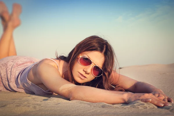 Meisje liggend op het zand — Stockfoto