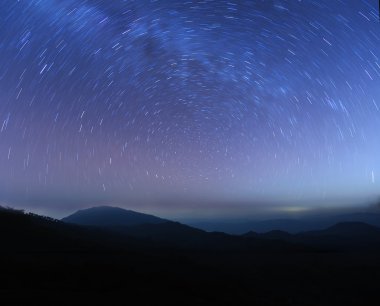 Star trails above high mountain clipart