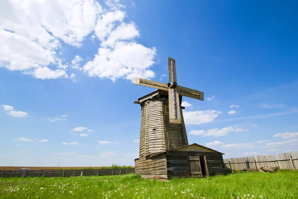 Dřevěný větrný mlýn na zelené louce — Stock fotografie