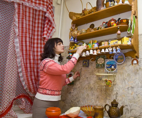 stock image Woman in kitchen taking the dishes from shelf