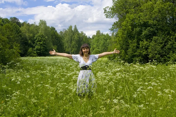 Young woman in white dress on a meadow in blossom — Stock Photo, Image