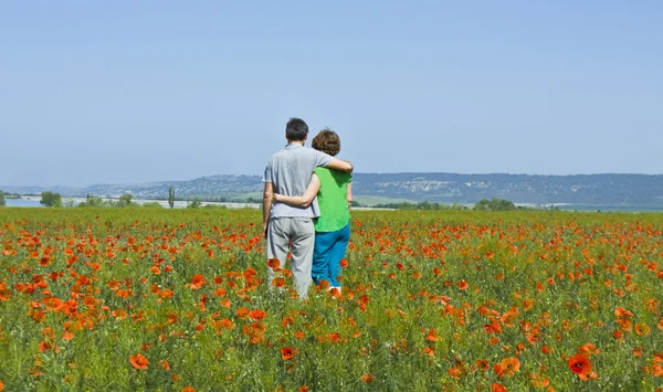 Couple on meadow with poppies — Stock Photo, Image