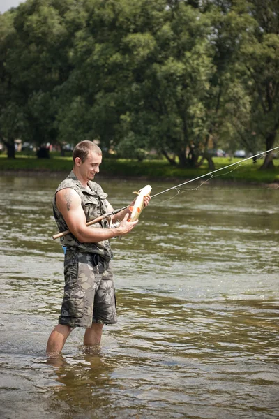 Gelukkig visser met een groot zoetwater kopvoorn. — Stockfoto