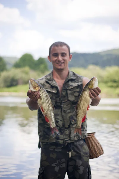 Happy angler with two freshwater chubs. Stock Picture