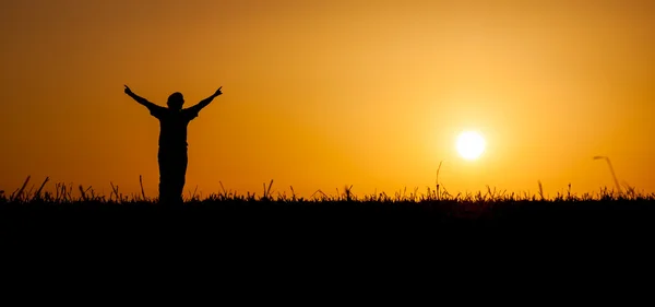 Pessoa que celebra a vida ao pôr do sol — Fotografia de Stock