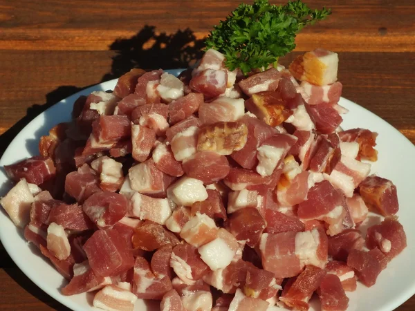Prosciutto cortar em dados bacon em close-up — Fotografia de Stock