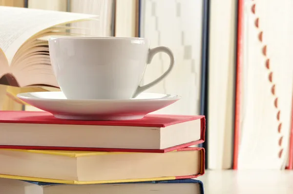 Состав со стопкой книг и чашкой кофе — стоковое фото