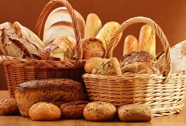 Složení s chlebem a rohlíky v proutěném koši — Stock fotografie