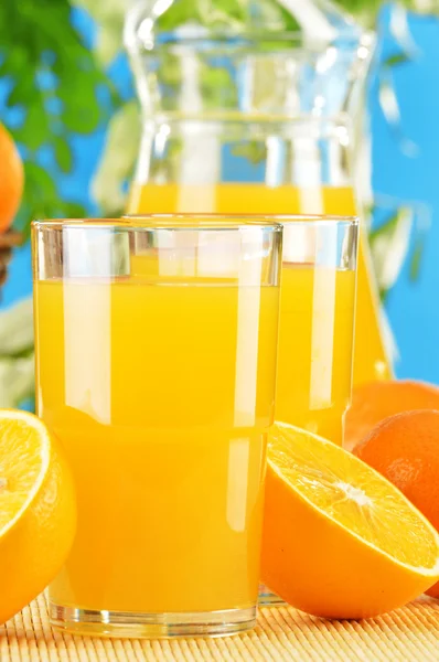 Komposition mit zwei Gläsern Orangensaft und Früchten — Stockfoto