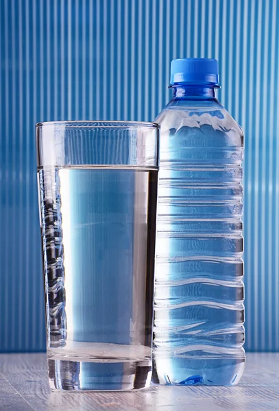Sammansättning med glas vatten på blå bakgrund — Stockfoto