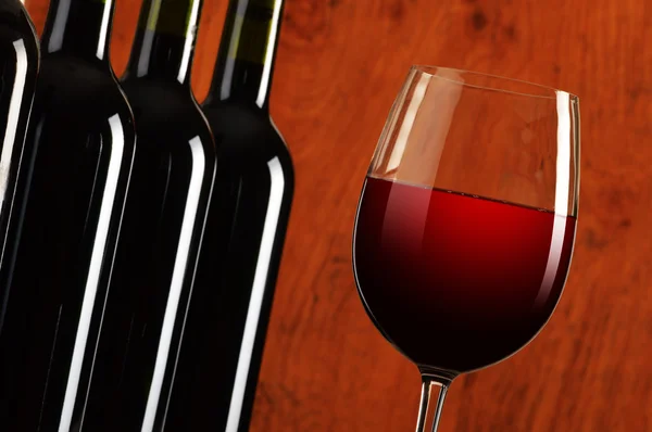 Композиция с двумя бокалами вина и бутылками красного вина — стоковое фото