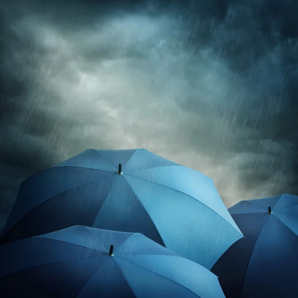 Nuvens escuras e guarda-chuvas — Fotografia de Stock