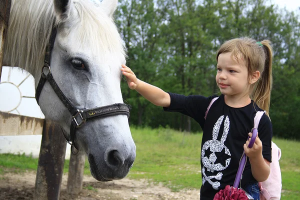Het kleine meisje en paard — Stockfoto