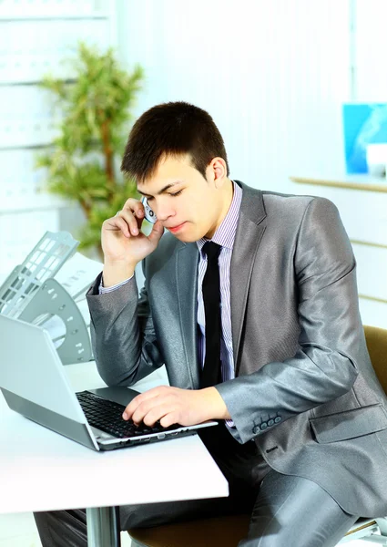 Portrait d'un homme d'affaires intelligent utilisant un ordinateur portable dans un bureau moderne — Photo