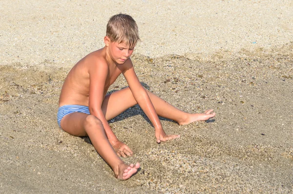 Хлопчик грає на піску на пляжі — стокове фото