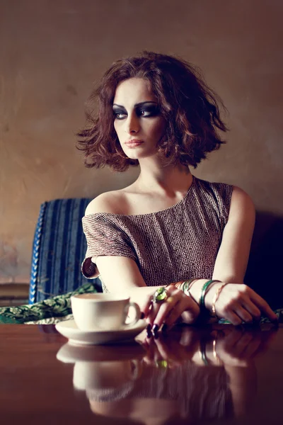 Piękna brunetka kobieta siedzi sama w restauracji — Zdjęcie stockowe