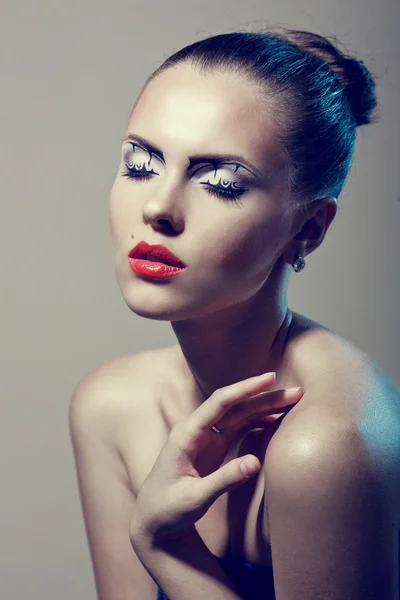 Gesicht einer schönen Frau mit kreativem Make-up und roten Lippen — Stockfoto
