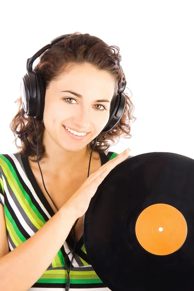 Hermosas mujeres jóvenes sonrientes DJ escuchando música en los auriculares y sosteniendo la placa de vinilo — Foto de Stock