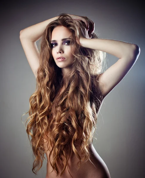 Sexy mladá žena s dlouhými kudrnatými vlasy krásné — Stock fotografie