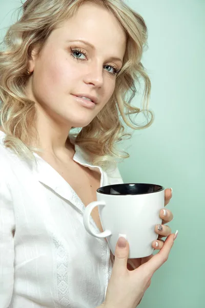 Chica joven con una taza de bebida caliente — Foto de Stock