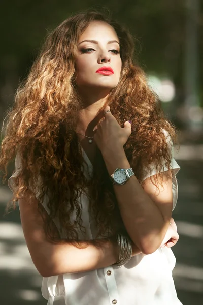Kaunis nuori nainen upea kihara tukka ulkona — kuvapankkivalokuva