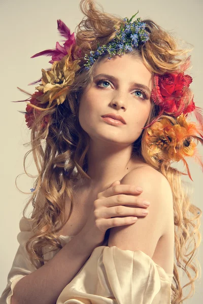 Stylized summer portrait of a young beautiful woman with flowers — Stock Photo, Image