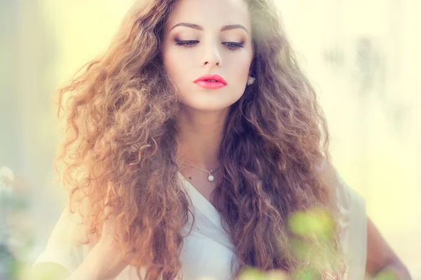 Hermosa mujer joven con hermoso pelo rizado al aire libre Imagen de archivo