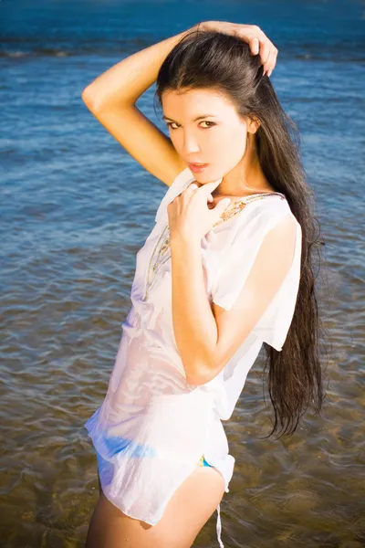 Bella ragazza bruna sensuale in piedi in acqua blu — Foto Stock