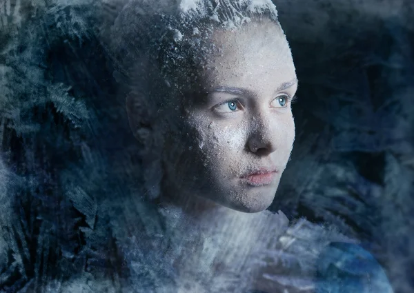 Красивая молодая девушка смотрит в холодное окно — стоковое фото