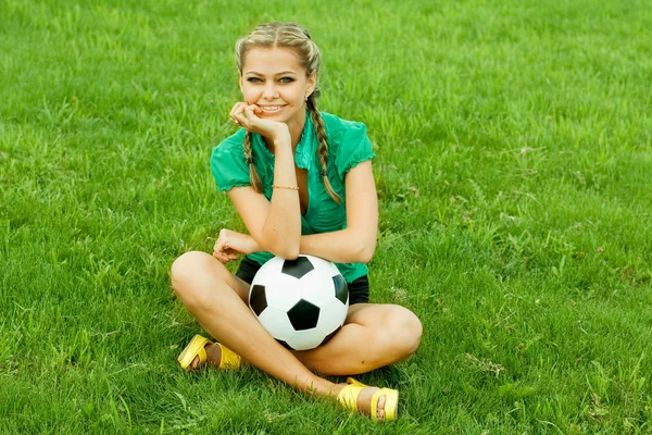 Piękna młoda kobieta z piłką, siedząc na zewnątrz — Zdjęcie stockowe