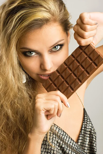チョコを食べて美しい若い女性のクローズ アップのスタジオ ポートレート — ストック写真
