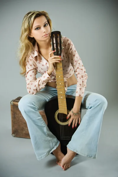 Studio portrait of a beautiful sexy young woman with black guitar — Stock Photo, Image