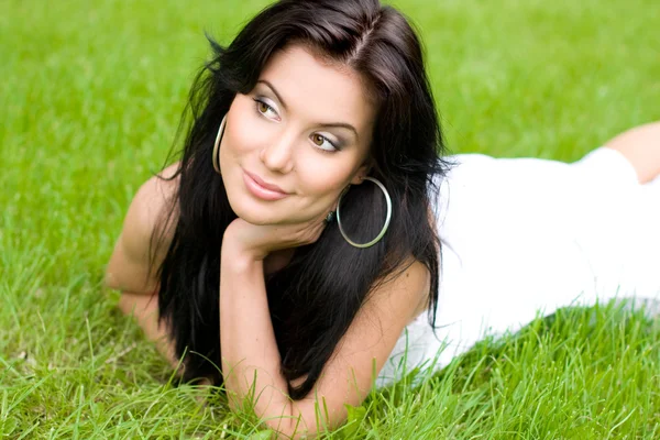 美しい芝生の上の若いブルネットの少女 — ストック写真