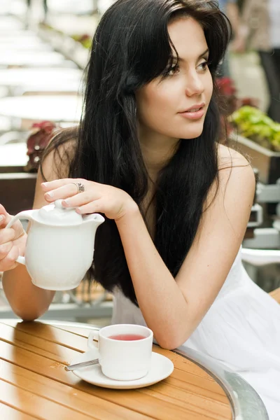 Hermosa mujer bebiendo té en un café — Foto de Stock