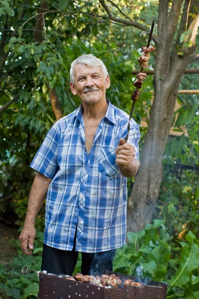 Пожилой человек с барбекю — стоковое фото