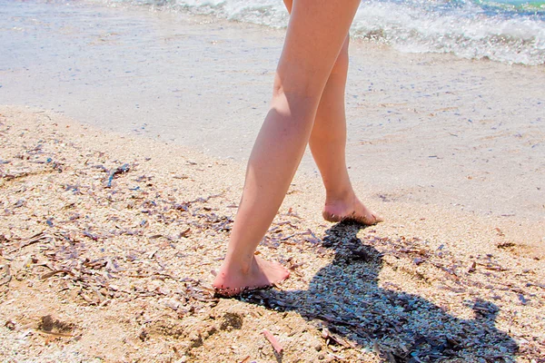 En kvinna som går på stranden — Stockfoto