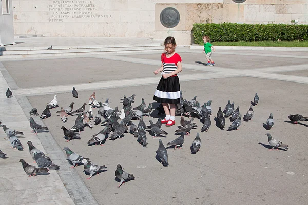 küçük bir kız bir sürü güvercin besleme