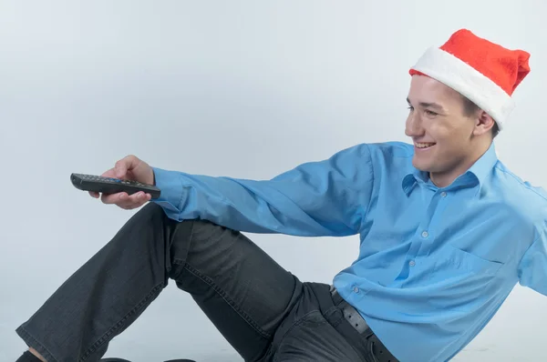 Een man met een afstandsbediening van de televisie kijken kerst tv — Stockfoto