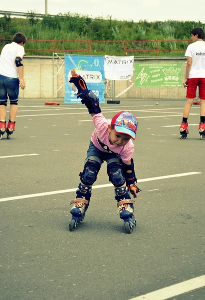 O menino patina em patinadores de rolo — Fotografia de Stock