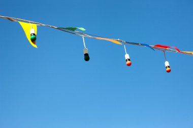 Boxes with colored light bulbs in the spring sky clipart