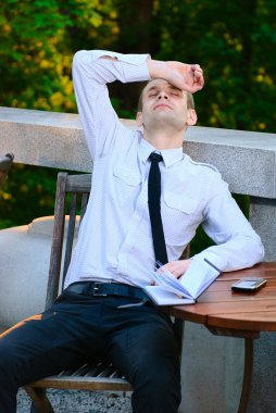 Hard day at work - Tired business man relaxing with hands on the head clipart