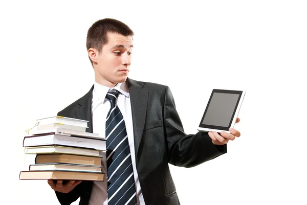 Бізнесмен стоїть на білому тлі і вибирає бітвен традиційні книги та електронний планшет — стокове фото