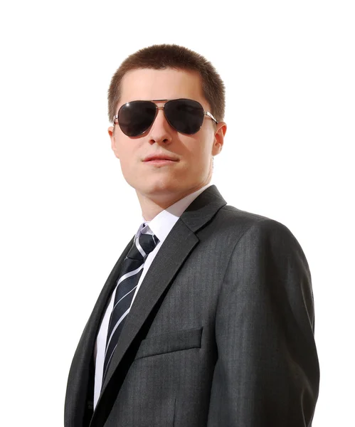 Молодой человек в костюме и солнечных очках на белом фоне — стоковое фото