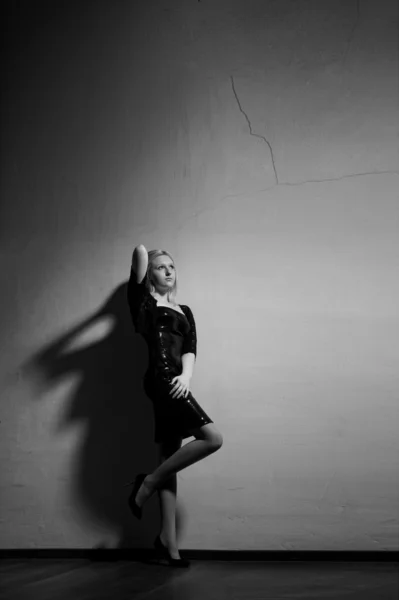 Bella donna con abito nero davanti al muro. Foto di moda — Foto Stock