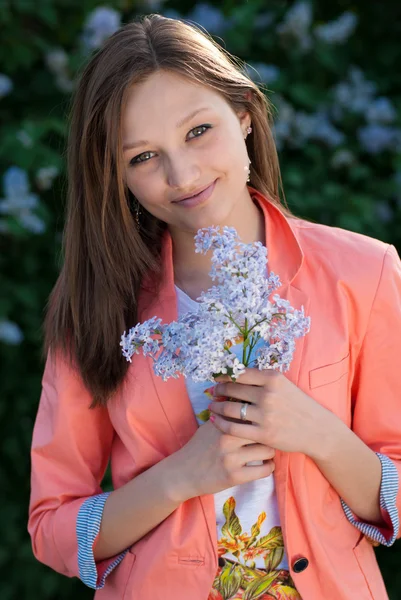 Jonge mooie vrouw lila bloemen ruiken — Stockfoto