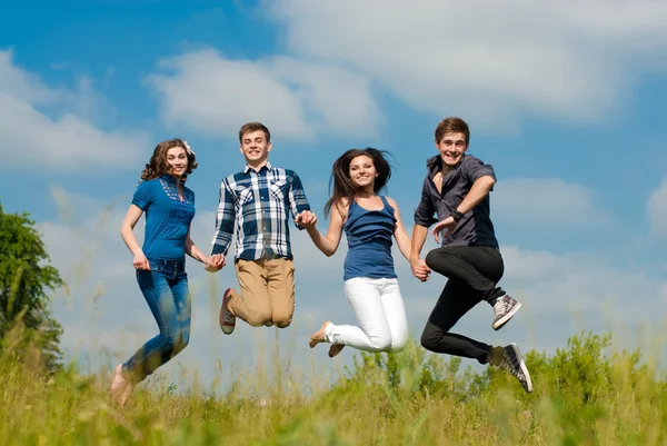 Four teens jumping high in sky — Stock Photo, Image