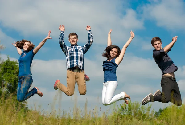 Four teens jumping high in sky — Stock Photo, Image